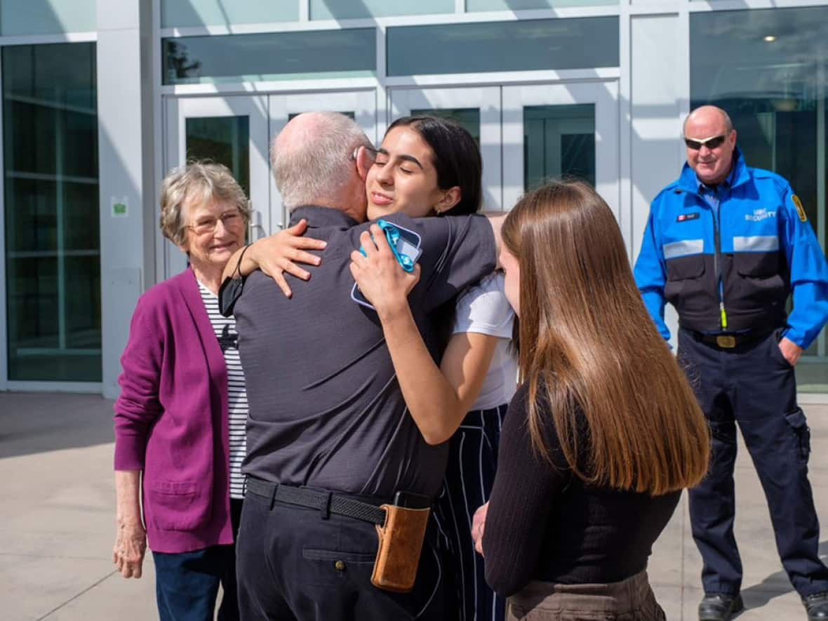 UBC Okanagan student Murray Forbes, 77, hugs classmate Kim Davarani during a meeting in which he got to directly thank her and other classmates who gave him more than 20 minutes of CPR in February after he had a heart attack on campus.  (UBC - image credit)