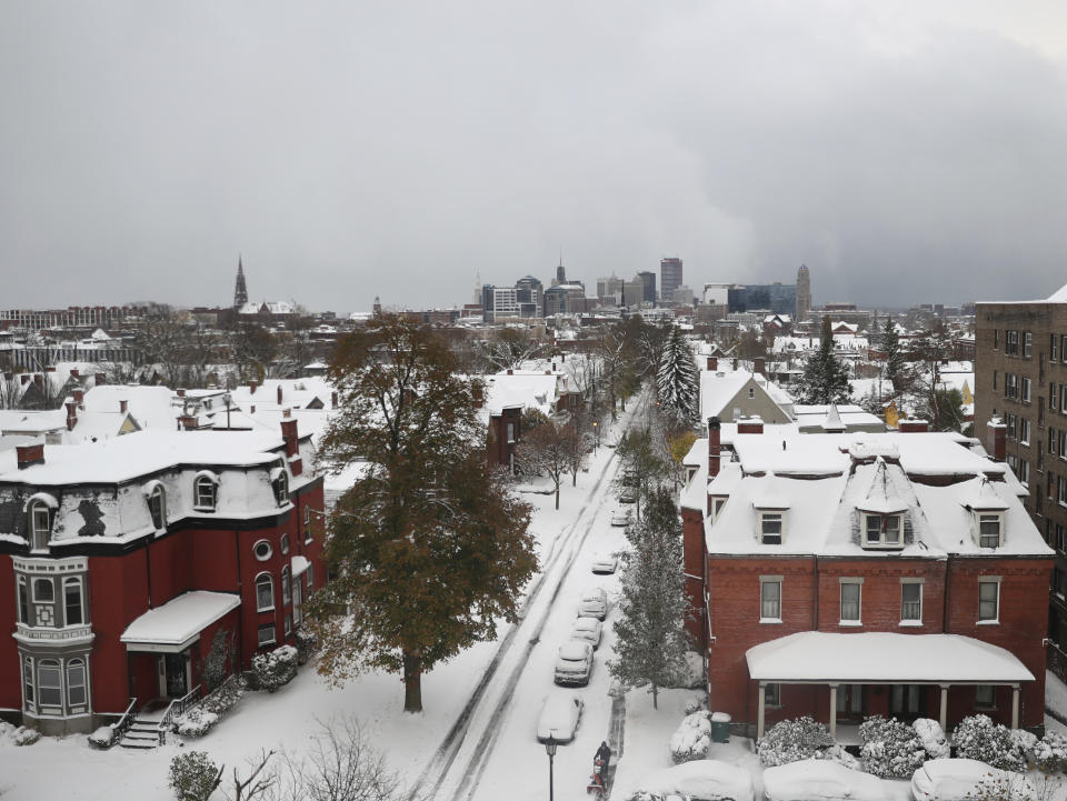 Homes and parked cars sit under a blanket of snow, Friday, Nov. 18, 2022, in Buffalo, N.Y. A dangerous lake-effect snowstorm paralyzed parts of western and northern New York on Friday, with nearly 2 feet (0.61 meters) of snow already on the ground in some places by midmorning and possibly much more on the way. (Joseph Cooke/The Buffalo News via AP)