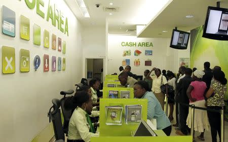 Customers queue for mobile money transfers, known as M-Pesa, inside the Safaricom mobile phone care centre in the central business district of Kenya's capital Nairobi July 15, 2013. REUTERS/Thomas Mukoya