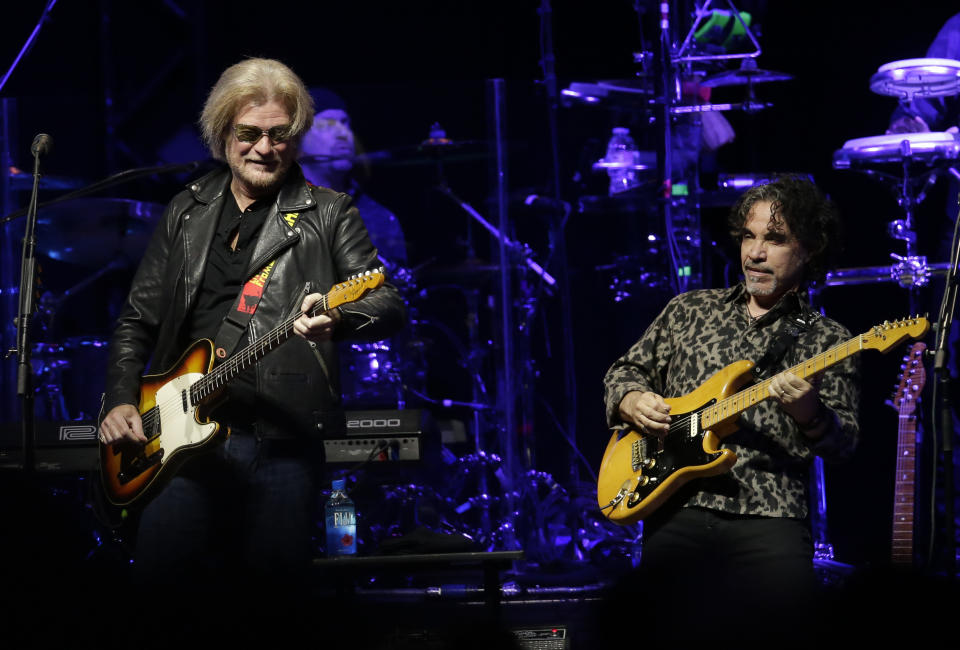 FILE - Daryl Hall, left, and John Oates perform in Glendale, Ariz. on July 17, 2017. After more than a half-century of making music together, Hall is suing Oates over a proposed sale of his share of a Hall & Oates business partnership that Hall says he hasn't approved. A Nashville judge recently paused the sale of Oates' stake in Whole Oats Enterprises LLP to Primary Wave IP Investment Management LLC pending arbitration, or until Feb. 17, 2024. (Photo by Rick Scuteri/Invision/AP, File)