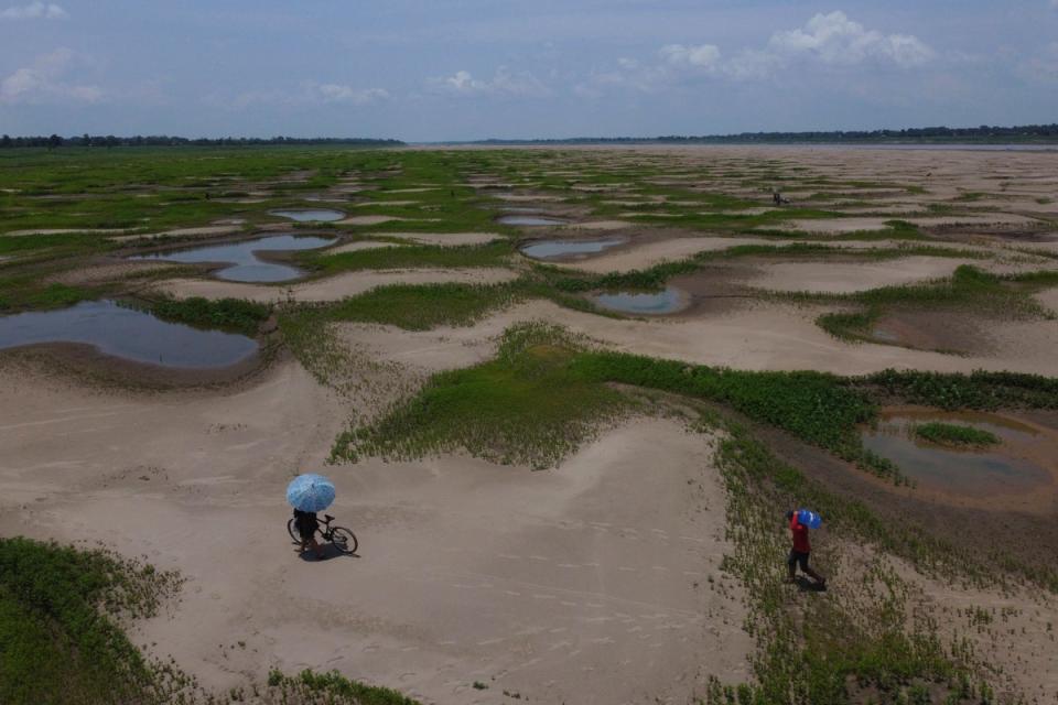 Residents of a riverside community carry food and containers of drinking water due to the ongoing drought and high temperatures that affect the region of the Solimoes River in Amazonas state, Brazil last month. The climate crisis is driving drought and water shortages around the world (Copyright 2023 The Associated Press. All rights reserved)