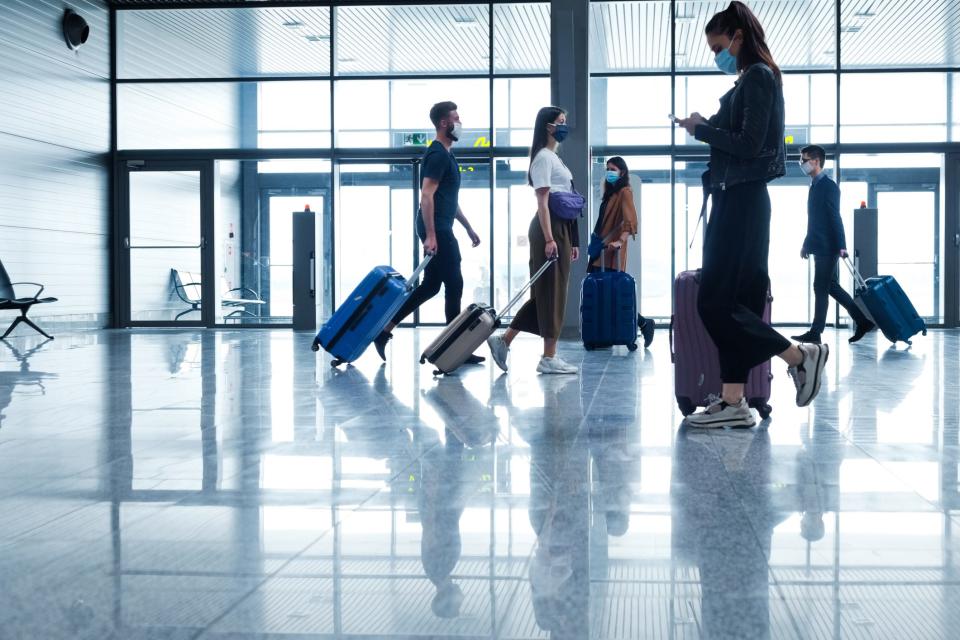 Travelers masked inside an airport.