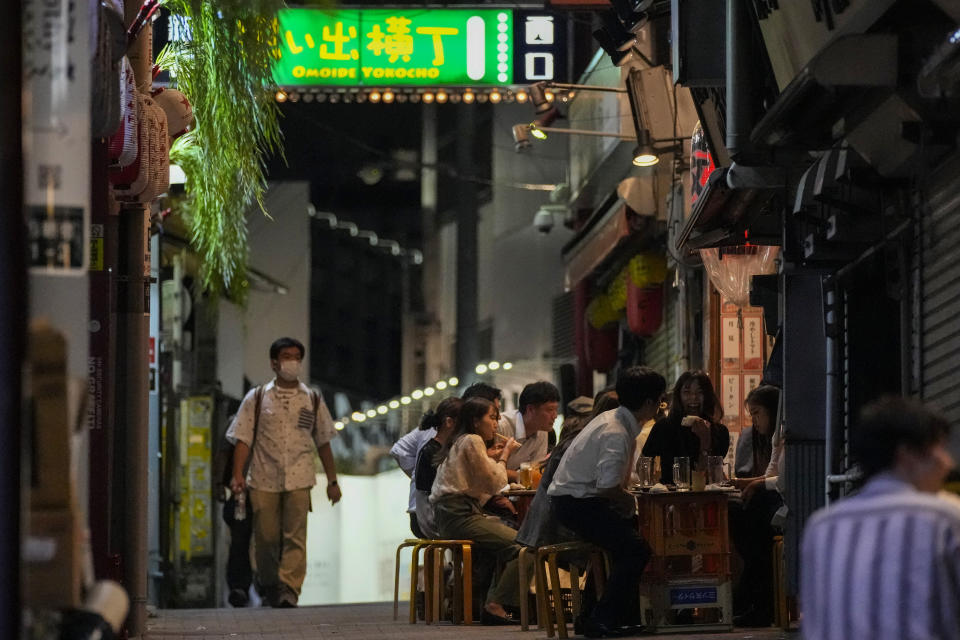 People gather at bars that are open and serving alcohol on an ally filled with bars and restaurants despite Tokyo government has requested businesses not to serve alcohol under the state of emergency Wednesday, Sept. 22, 2021, in Tokyo. Japan is set on Tuesday, Sept. 28, 2021 to lift ongoing coronavirus state of emergency and less-stringent measures in all 27 prefectures including Tokyo when they expire at the end of September as the infections slow and the nation tries to reactivate its economy. (AP Photo/Kiichiro Sato)