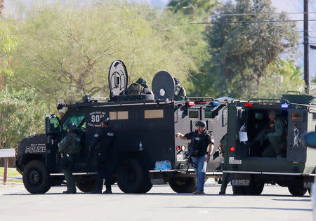 Police officers are shown near their armored vehicles during a standoff where three officers were shot by a suspect in Palm Springs, California, U.S. October 8, 2016. REUTERS/Sam Mircovich