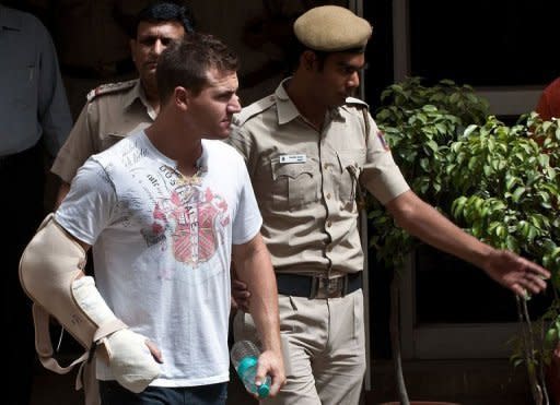 Delhi policemen escort Australian cricketer Luke Pomersbach (C) before a court appearance in New Delhi. Indian police on Friday arrested and charged Pomersbach with molesting a woman and badly beating up her fiance after a late-night party at a posh New Delhi hotel