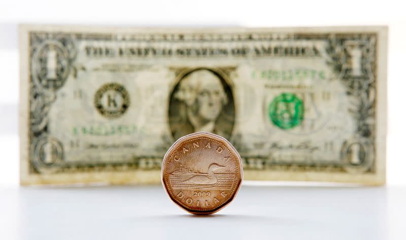 FILE PHOTO: A Canadian dollar coin, commonly called a "loonie," and an American dollar bill are seen in this staged photo in Toronto