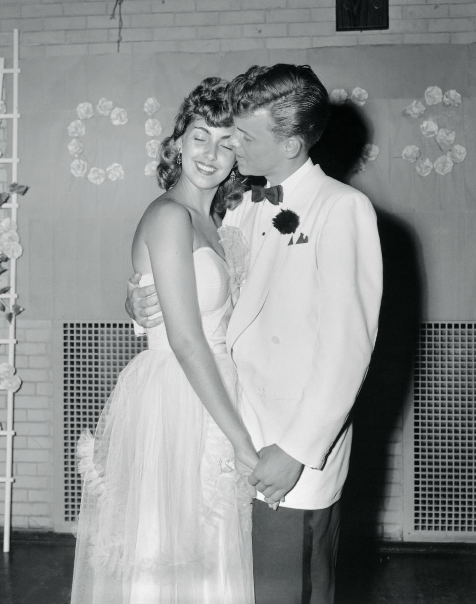 A couple posing for a prom photo in 1953