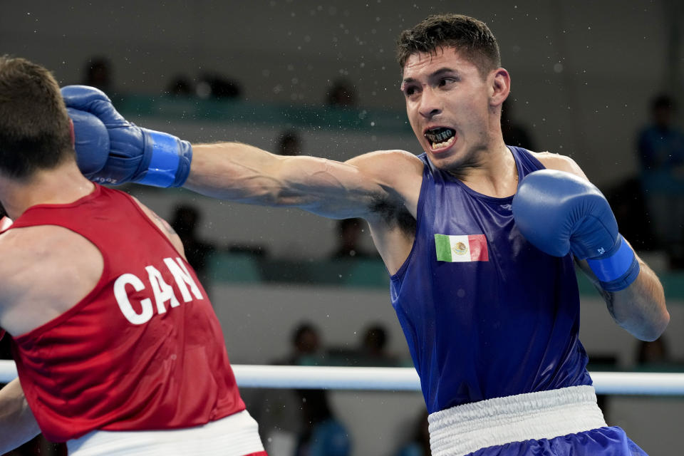 El canadiense Wyatt Sanford (izquierda) y el mexicano Miguel Martínez compiten en la pelea por la medalla de oro de los 63.5kg de los Juegos Panamericanos en Santiago, Chile, el viernes 27 de octubre de 2023. (AP Foto/Martín Mejía)