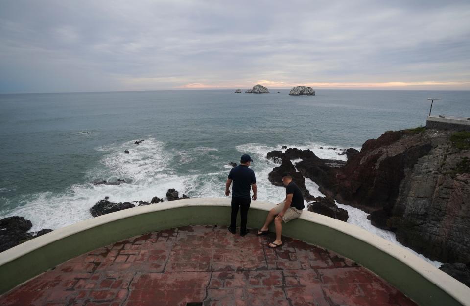 People relax at the shore in Mazatlan, Mexico, Sunday, Oct. 2, 2022. Hurricane Orlene, at Category 3 strength, is heading for a collision with Mexico's northwest Pacific coast between the tourist towns of Mazatlan and San Blas. (AP Photo/Fernando Llano)