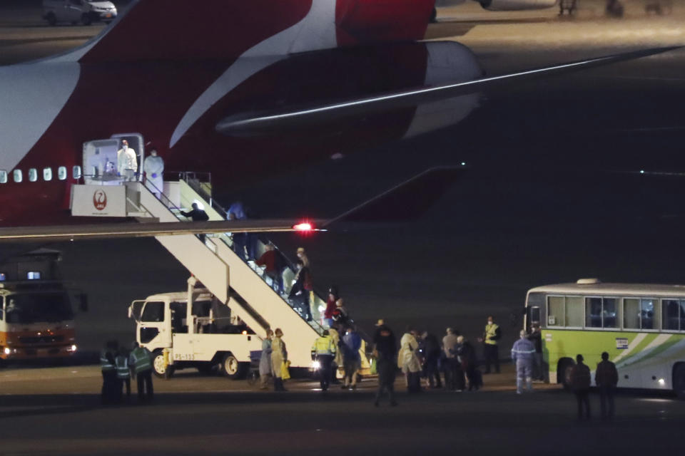 Passengers from the quarantined Diamond Princess cruise ship board an airplane at Haneda airport in Tokyo Wednesday, Feb. 19, 2020. Hundreds of passengers began leaving the Diamond Princess cruise ship Wednesday after the end of a much-criticized, two-week quarantine that failed to stop the spread of a new virus among passengers and crew.(AP Photo/Koji Sasahara)