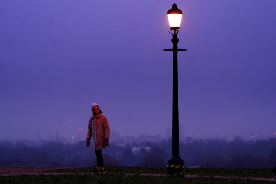 A woman walks during misty weather in Primrose Hill, London (PA)