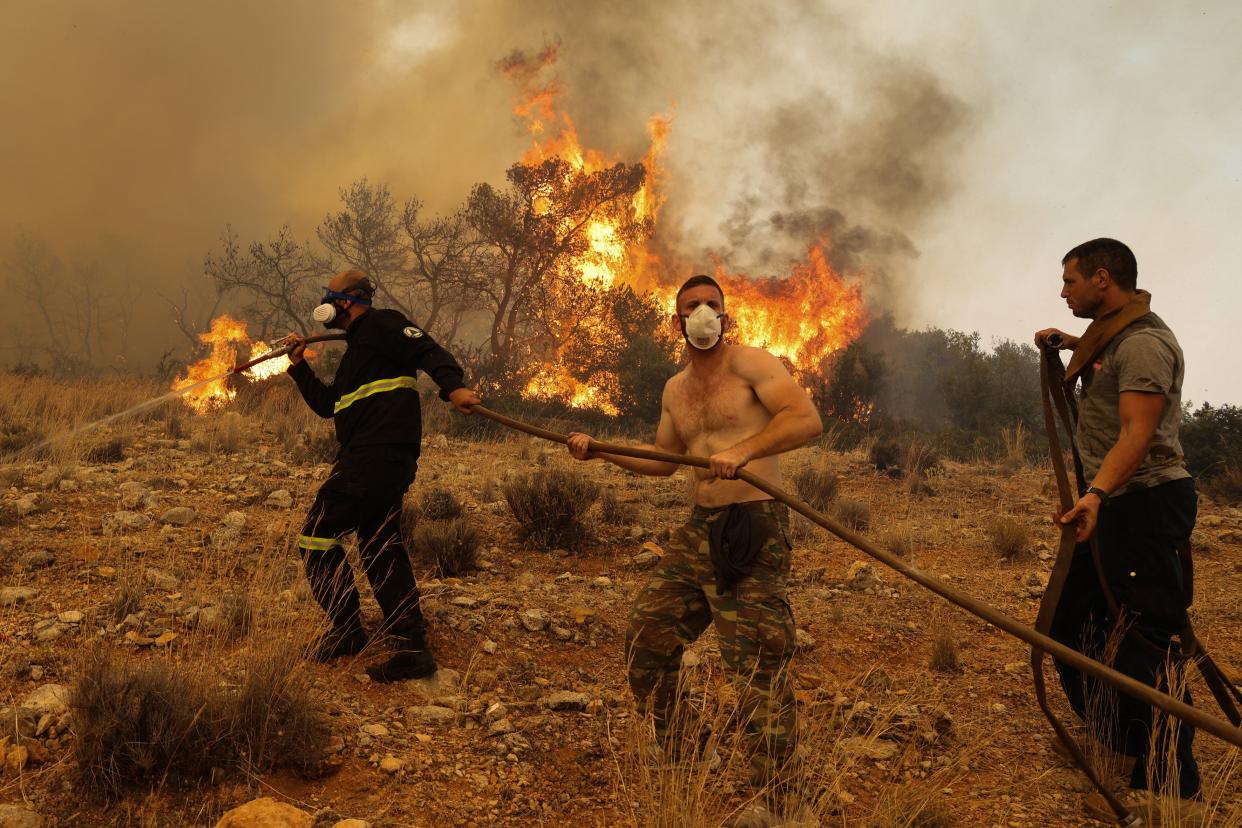 Firefighter teams intervene a wildfire at the village of Ano Vlichada, near Athens (Anadolu Agency via Getty Images)