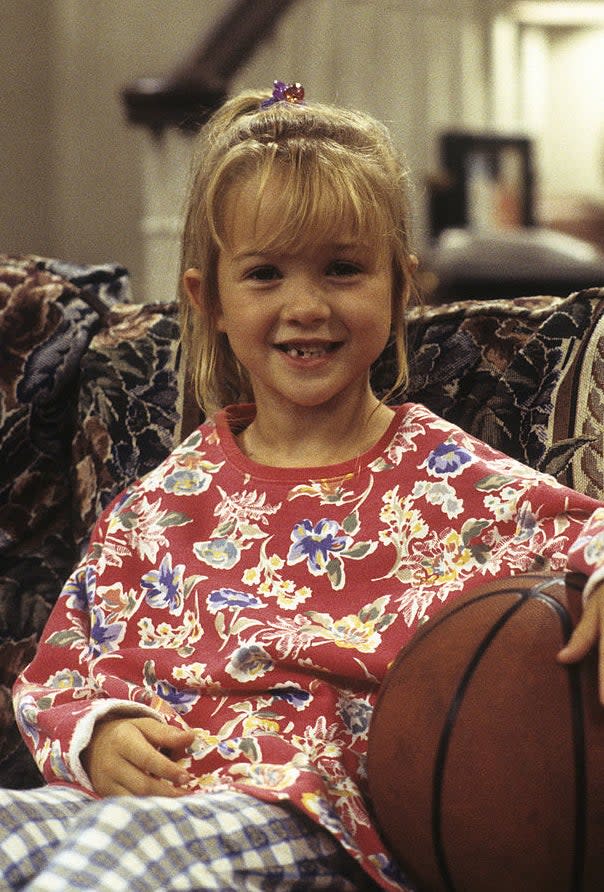 closeup of her as a kid sitting with a basketball