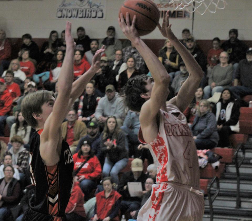 Onaway junior Cole Selke (4) goes up strong to the basket while Cheboygan junior Brennen Thater (left) attempts to make a block during the first half on Friday.