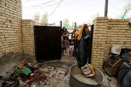 People gather at the site of a suicide bomb attack in the city's northern al-Shaab district in Baghdad, Iraq October 15, 2016. REUTERS/Ahmed Saad