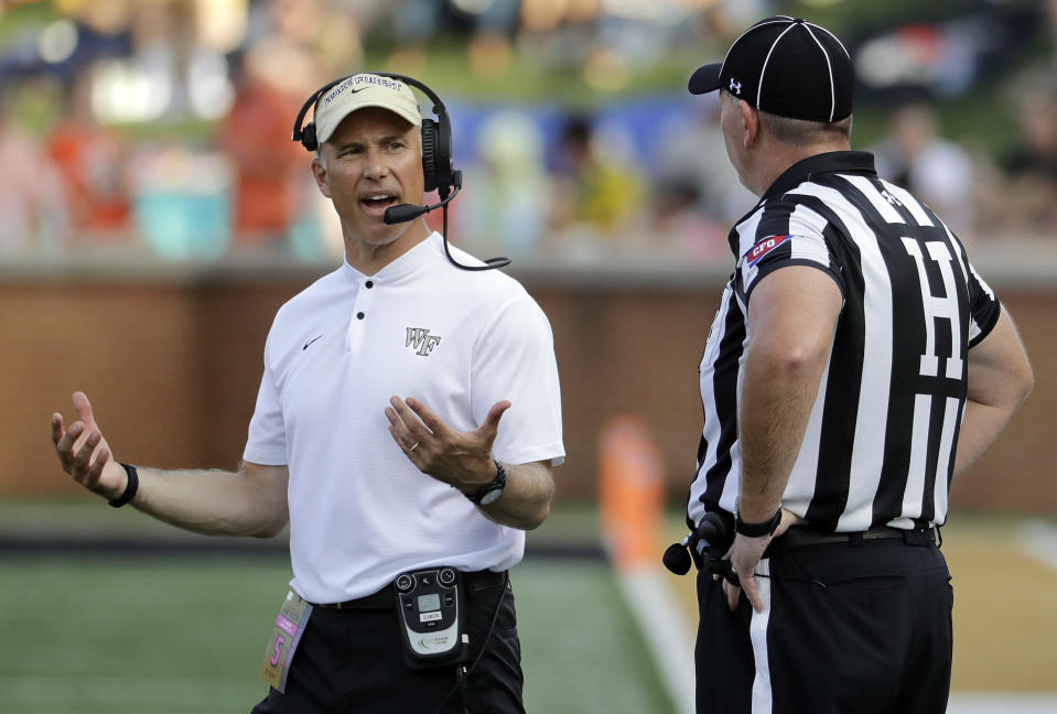 Wake Forest head coach Dave Clawson, left, argues a call during the first half of an NCAA college football game against Clemson in Charlotte, N.C., Saturday, Oct. 6, 2018. (AP Photo/Chuck Burton)