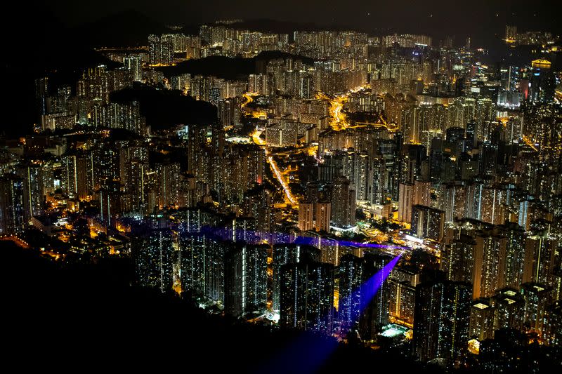 FILE PHOTO: Laser beams, coming from the residential buildings in Kowloon district, are seen as anti-government protesters gather at Lion Rock, in Hong Kong