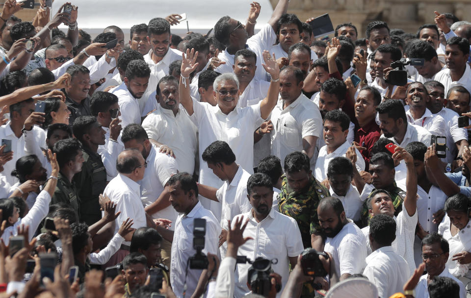 Sri Lanka's newly elected president Gotabaya Rajapaksa, center, greets people as he leaves after the swearing in ceremony held at the 140 B.C Ruwanweli Seya Buddhist temple in ancient kingdom of Anuradhapura in north central Sri Lanka Monday, Nov. 18, 2019. The former defense official credited with ending a long civil war was Monday sworn in as Sri Lanka’s seventh president after comfortably winning last Saturday’s presidential election. (AP Photo/Eranga Jayawardena)