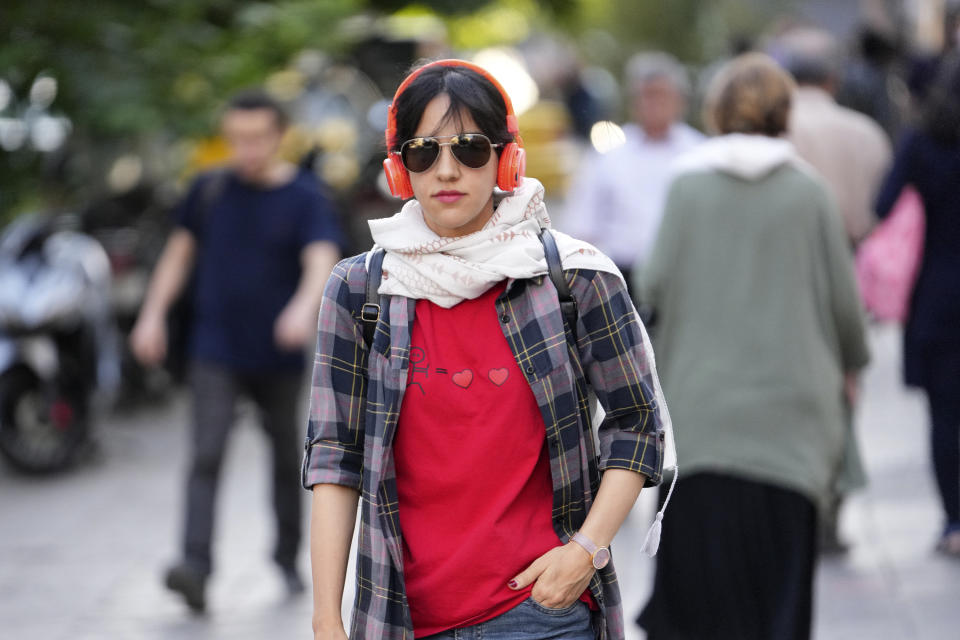 A woman without wearing her mandatory Islamic headscarf walks in downtown Tehran, Iran, Saturday, Sept. 9, 2023. Iranians are marking the first anniversary of nationwide protests over the country's mandatory headscarf law that erupted after the death of a young woman detained by morality police. (AP Photo/Vahid Salemi)