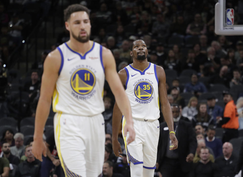 Golden State Warriors forward Kevin Durant (35) and guard Klay Thompson (11) walk off the court during a timeout during the first half of an NBA basketball game San Antonio Spurs, Sunday, Nov. 18, 2018, in San Antonio. (AP Photo/Eric Gay)