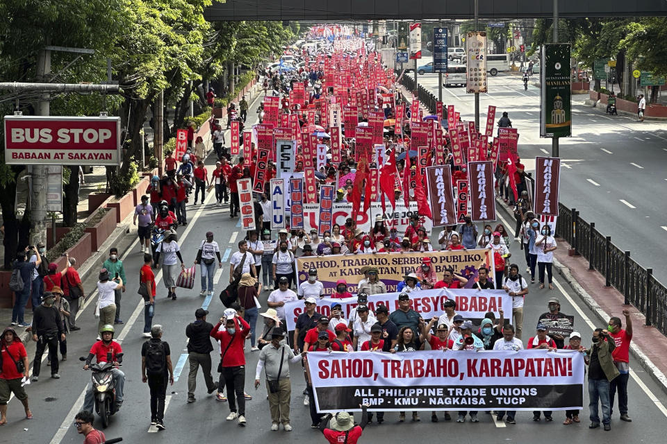 Filipino protesters hold slogans as they march along a road to mark International Labor Day in Manila, Philippines on Monday May 1, 2023. Thousands of Filipino workers marched in the streets of Manila on Monday, reiterating their calls to the government to increase the basic minimum wage, protect jobs in the country. (AP Photo/Joeal Calupitan)