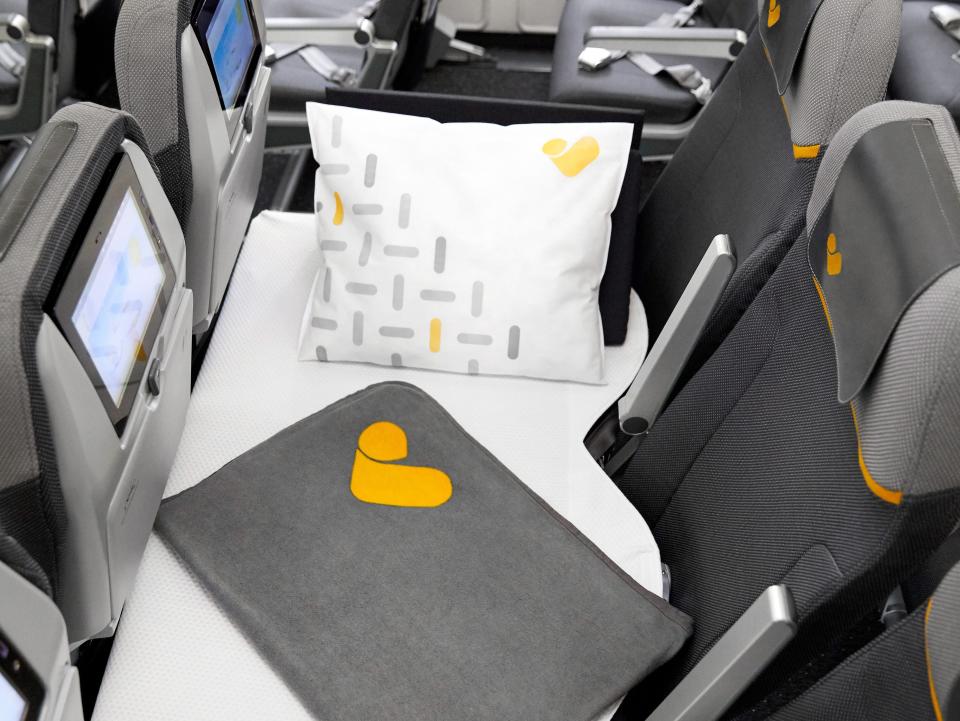 A "Sleeper Seat" once offered by Thomas Cook with white bedding and black seats.