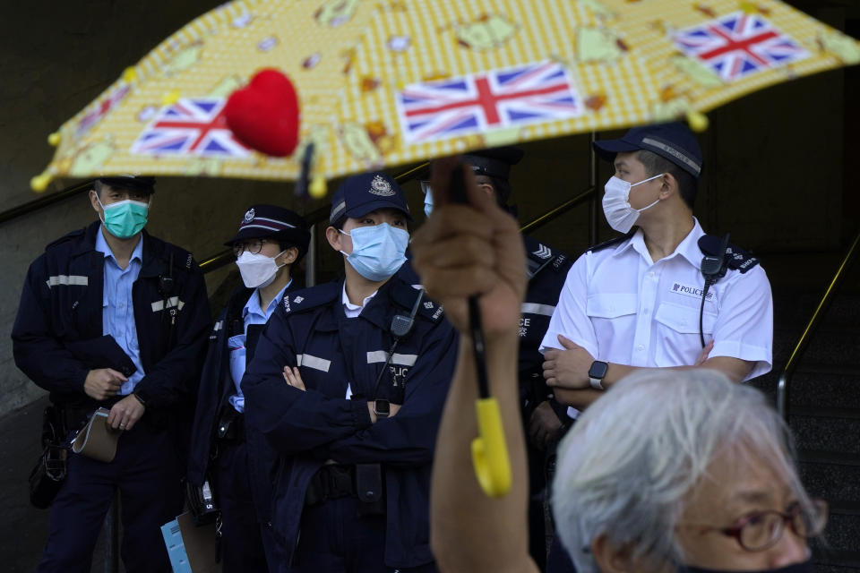 Pro-democracy activist Alexandra Wong holding yellow umbrella with British flags protests outside the Chinese central government's liaison office, in Hong Kong, Monday, Dec. 28, 2020, to demand the release of the 12 Hong Kong activists detained at sea by Chinese authorities. (AP Photo/Kin Cheung)