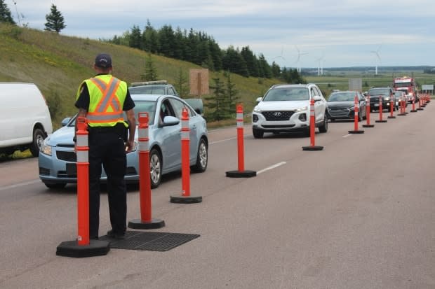 A peace officer directs traffic at the Aulac point of entry into New Brunswick from Nova Scotia in 2020. (Alexandre Silberman/CBC - image credit)