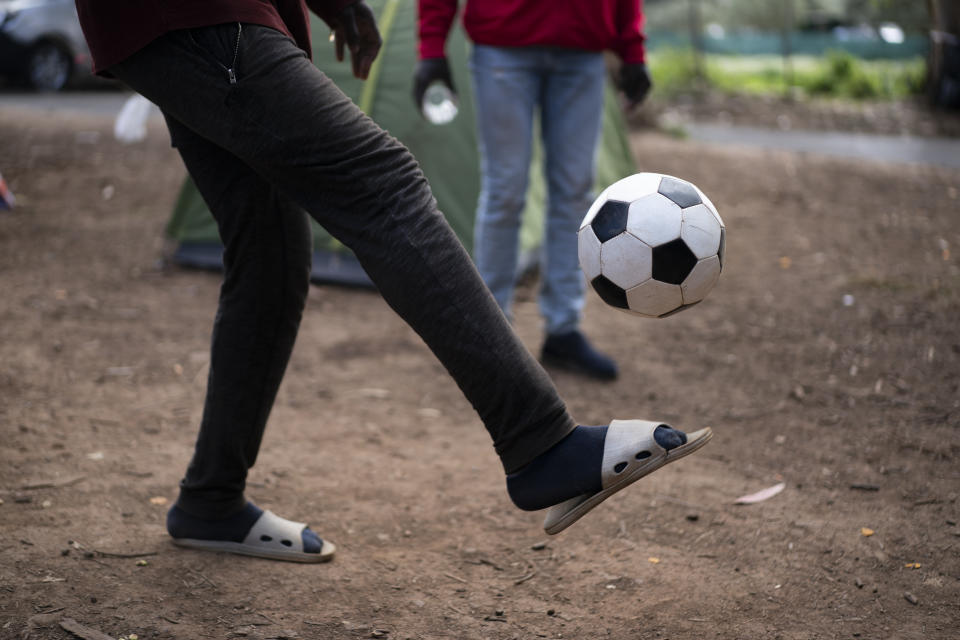 People play soccer at Las Raices camp in San Cristobal de la Laguna, in the Canary Island of Tenerife, Spain, Saturday, March 20, 2021. While Spain has been critical of its European neighbours' lack of solidarity when it comes to sharing the responsibility of migration, the country is similarly being criticized by migrants, authorities and human rights organizations on the Canary Islands where some 23,000 people arrived by sea last year and where many thousands remain on the island forcefully. (AP Photo/Joan Mateu)