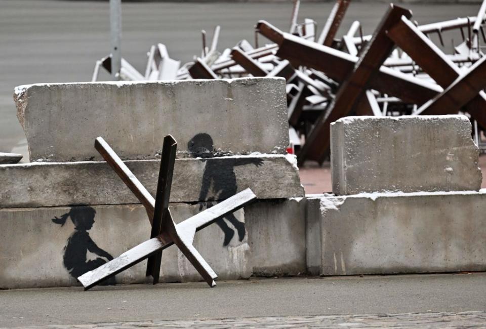 A photograph of graffiti presumably by England-based street artist Banksy behind an anti-tank hedgehog in Kyiv, Ukraine, on Nov. 17, 2022. (Sergei Supinsky/AFP via Getty Images)