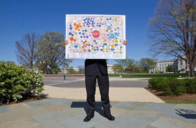 Glynn McGehee, an aide with Rep. Tom Price, R-Ga., holds a poster that mocks the organizational complexity of the health care law being argued.