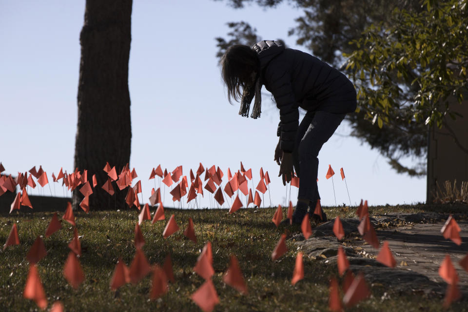 Cindy Pollock revisa las banderas que colocó en su jardín, el miércoles 10 de febrero de 2021, en Boise, Idaho. (AP Foto/Otto Kitsinger)