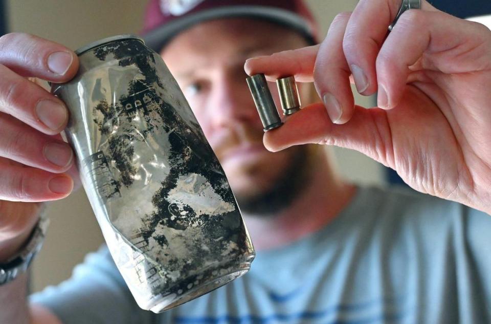 Ty Gillette shows a beer can with imprinted production date and shell casings he found as he and others independently pursue the source of the Creek Fire in an interview at his home Thursday, May 26, 2022 near Meadow Lakes, CA.