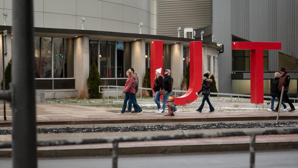 Hockey fans walk towards an entrance to the Adirondack Bank Center in Utica, NY.