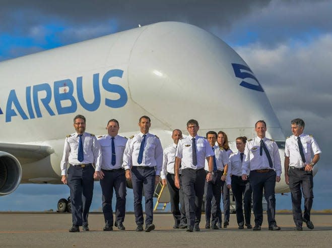 Pilots in uniform walking towards the camera in front of a BelugaST.