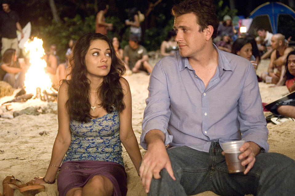 Mia Kunis and Jason Segal staring at one another in front of a beachside bonfire during a scene from "Forgetting Sarah Marshall"