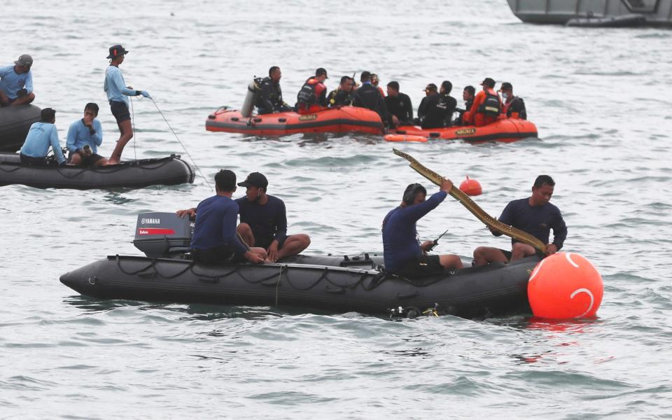 Rescuers carry debris found in the waters around the location where a Sriwijaya Air passenger jet lost contact with air traffic controllers  - AP