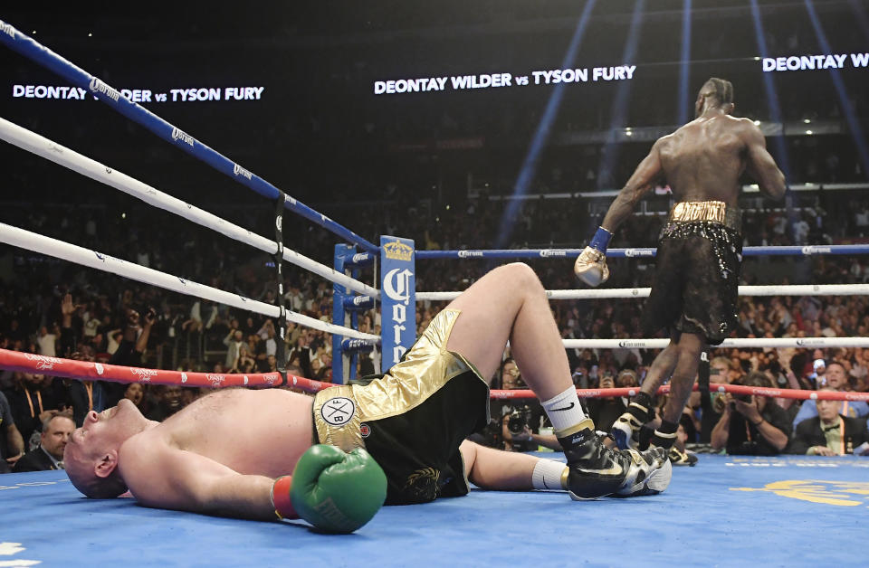 FIEL - In this Saturday, Dec. 1, 2018, file photo, Tyson Fury, of England, lies on the canvas after being knocked down by Deontay Wilder during the 12th round of a WBC heavyweight championship boxing match in Los Angeles. The bout ended in a draw. (AP Photo/Mark J. Terrill, File)