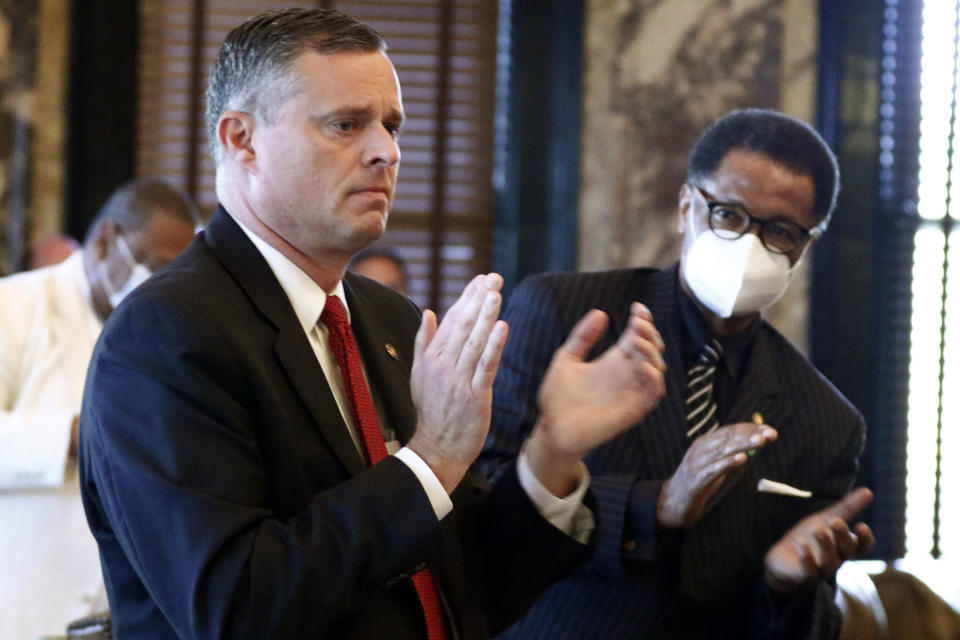 FILE - In this June 28, 2020, file photo, Sens. Chad McMahan, left, R-Guntown, and Sollie Norwood, D-Jackson, applaud after the Senate approved legislation to change the state flag, at the Capitol in Jackson, Miss. Mississippi is seeing the largest outbreak of COVID-19 among legislators in any state. McMahan said he never heard legislators express ideological reasons for going bare-faced, as he did. He said in a phone interview Thursday, July 9, that he washed his hands and did his best to keep distance between himself and others. (AP Photo/Rogelio V. Solis, File)