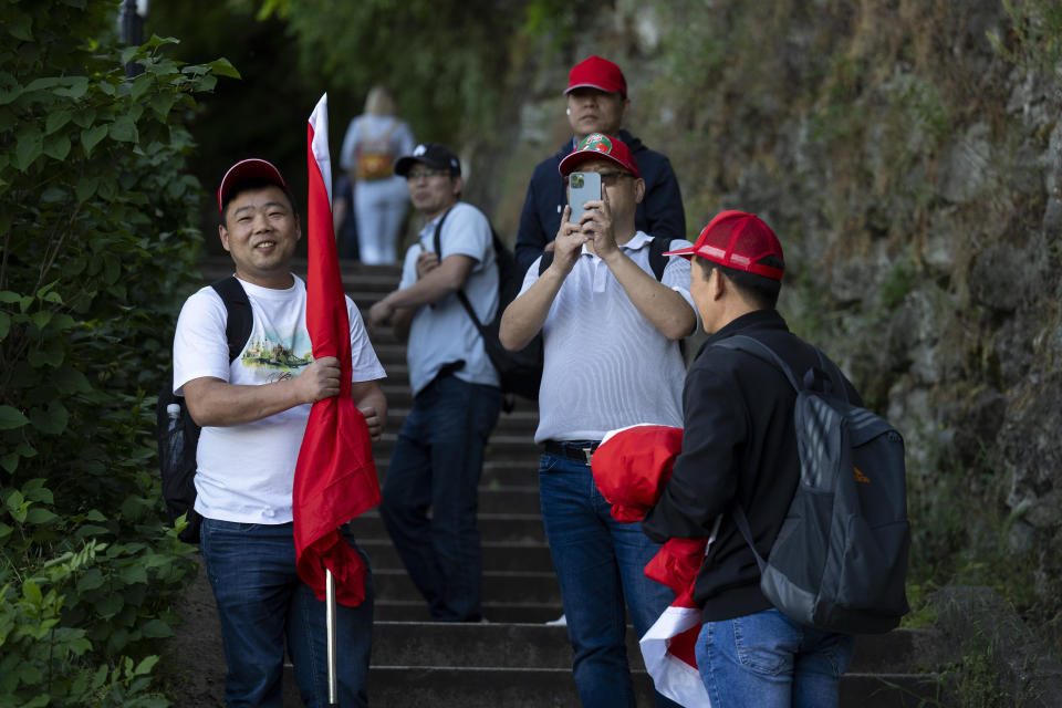 Chinese nationals take pictures of Tibetan protesters during Xi Jinping's visit to Budapest, Hungary, on Thursday, May 9, 2024. Many Chinese nationals claiming to be volunteers with China's embassy are present in the city, wearing red baseball caps to identify themselves. (AP Photo/Denes Erdos)