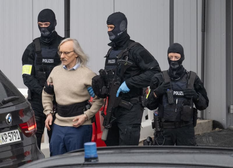 Defendant Maximilian Eder is led out of the court building by police officers after the end of the first day of the second and most high-profile trial linked to a far-right coup plot in Germany. The alleged 72-year-old ringleader, Prince Heinrich XIII of Reuss, is now facing the court. Boris Roessler/dpa