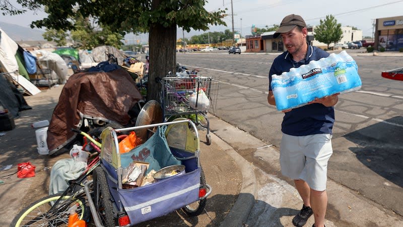 Ed Bluemel delivers a case of water to a homeless camp on 800 South during a heat wave in Salt Lake City on Monday, July 12, 2021. Bluemel and his brother, Cory Bluemel, raised over $700 to deliver ice, beverages and snacks to the homeless.