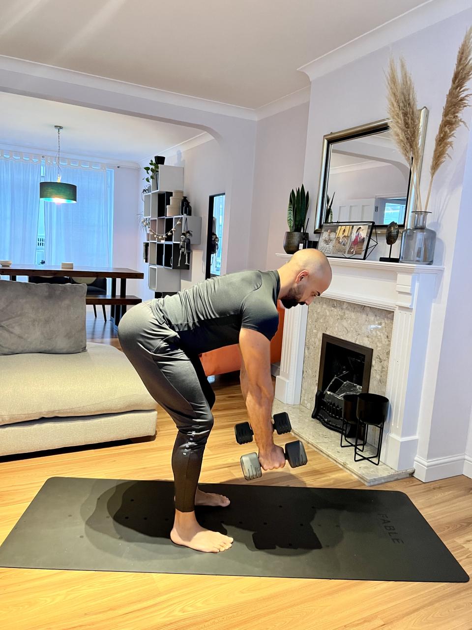 Personal trainer Ali Malik demonstrating the  dumbbell bent-over row