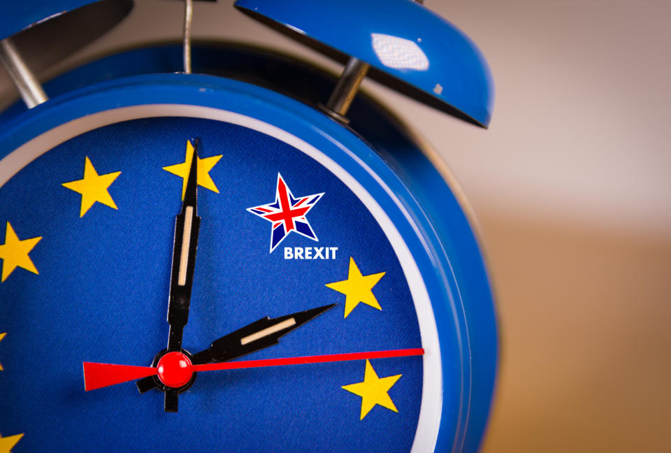A clock in the colors of the European flag with the minute hand moving toward a star in the colors of the Union Jack, which is labeled "Brexit"