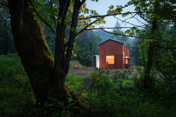 Surrounded by densely forested terrain, the secluded property at the foothills of the Cascade Mountains had a natural clearing carved in—this small meadow became the site for the Seattle couple’s family gateway.