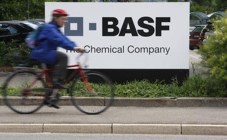 FILE PHOTO: A cyclist rides his bike past the entrance of the BASF plant and former Ciba production site in Schweizerhalle near Basel July 7, 2009. REUTERS/Christian Hartmann/File Photo