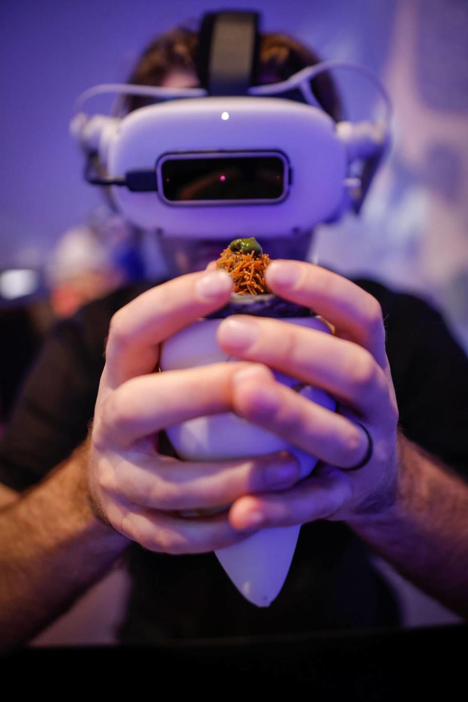 A guest prepares to try one of the multi-layered bites at “Aerobanquets RMX” while wearing a VR headset.