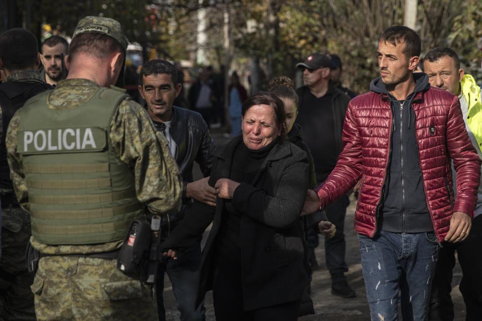 A woman mourns after rescuers found the body of a relative after an earthquake in Thumane, western Albania, Wednesday, Nov. 27, 2019. Overnight, authorities said four more people had been confirmed dead, and one more death was reported early Wednesday afternoon, raising the death toll to 26, while more than 650 people were injured in the magnitude-6.4 quake that struck the country's coastal cities. (AP Photo/Petros Giannakouris)