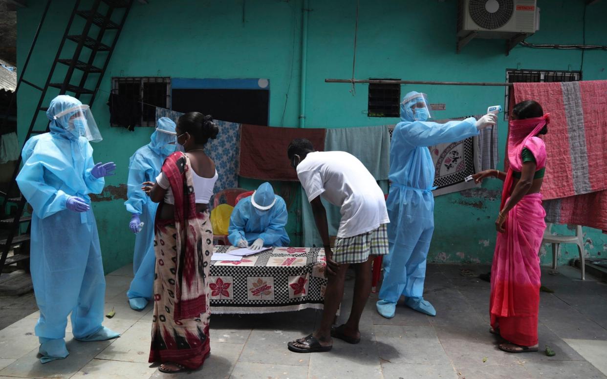 Doctors examines people during a free medical camp in Dharavi, one of Asia's largest slums in Mumbai - AP