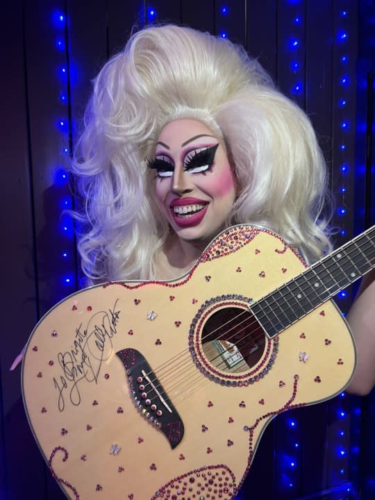 Drag performer Brigitte Bandit holds the sparkly guitar sent to her and signed by Dolly Parton. (Courtesy: Brigitte Bandit)